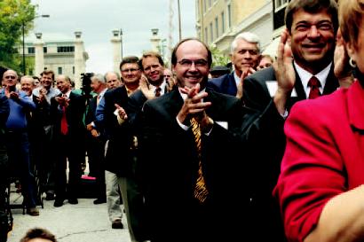 In foreground, from left: REDI President Mike Brooks, attorney Craig Van Matre and Boone County National Bank CEO Steve Erdel applaud IBM's announcement. The three were key players in Project Tiger.