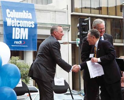 IBM Vice President Tim Shaughnessy shakes hands with former Mayor Darwin Hindman on stage with Gov. Jay Nixon during IBM's announcement May 17.