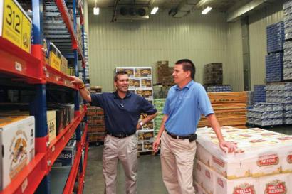 Joe Preismeyer, left, and Kevin Wisch check product inventory levels of the company's imports and specialty beer brands. Preismeyer recently became president of N.H. Scheppers Distributing Company.