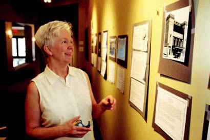 Marge Berchek works on hanging her exhibit on historic vaudeville and moving picture theaters in Columbia. On display at the Missouri Theatre, the exhibit will open in July.