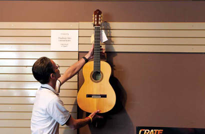 Michael Barnes prepares to tune the last guitar for sale at Hennessy and Sons.