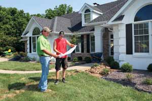 Rost looks over plans with Josh Randolph for a residental landscape project in southwest Columbia.