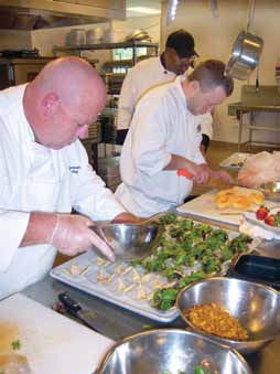 Chefs prepare food for an academic institution. The food service company serves fresh food to more than 20 dining facilities in Missouri.