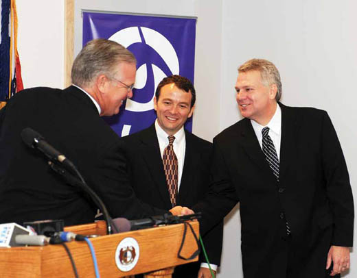 Gov. Jay Nixon congratulates Socket executives Carson Coffman and George Pfenenger during a news conference at the company's headquarters.