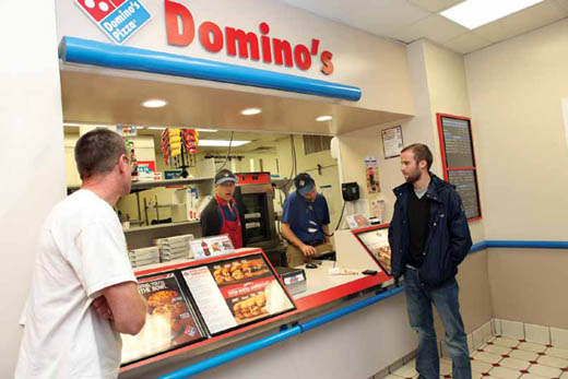 Customers wait for their pizzas on a busy, rainy night at Domino's Pizza.