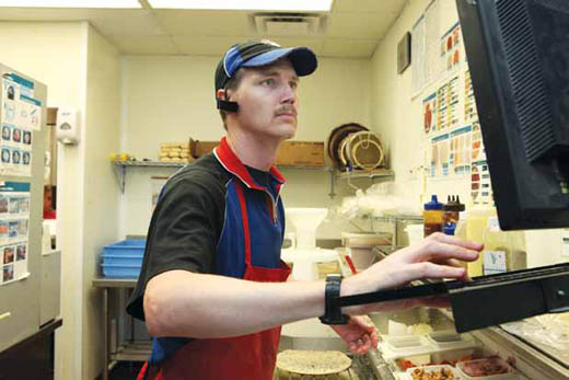 Domino's General Manager William Maddox checks the order screen on a busy night.