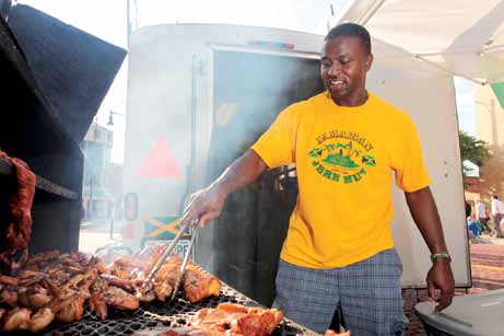 Rexroy Scott of the Jamaican Jerk Hut tends to the barbecue at the festival.