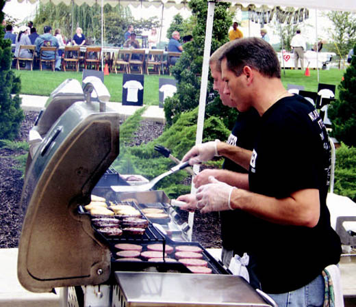 MEM employees Bob Steinmetz and Jake Novinger volunteer their time to grill burgers for the Keene Street event.