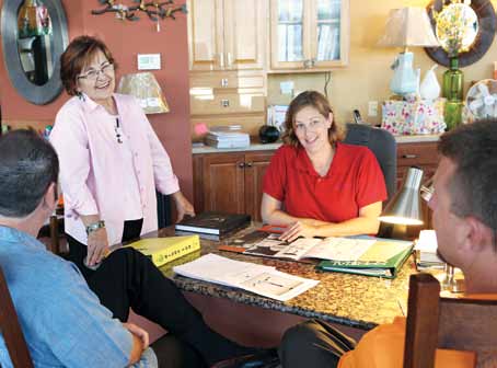 Kay Wax, left, and Sarah McAnelly discuss light fixtures for a house project with two clients.
