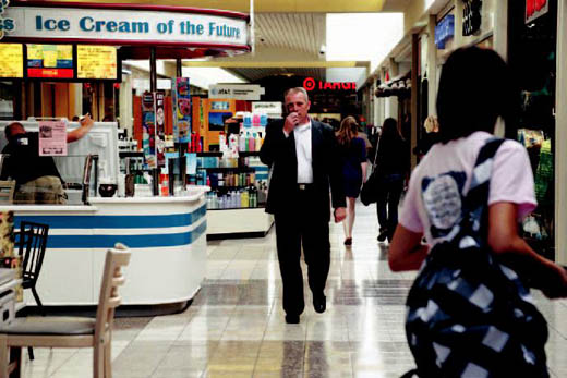 Strodtman converses with associates on his walkie-talkie as he surveys the Columbia Mall during a busy afternoon when Columbia schools had an early dismissal.