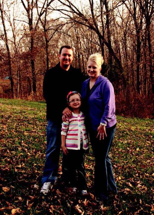 Kris Farmer stands in his backyard with wife, Christi, and his daughter, Paige. Farmer’s home in the Cascades subdivision is near one of the proposed routes for a 161,000-volt transmission line connecting a new Water and Light substation with one in McBaine. He and other homeowners are concerned the lines will hurt property values and could cause adverse health effects.