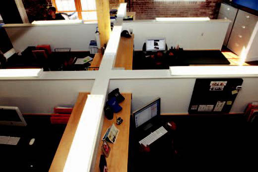 Employees work on creative projects in an open office setting.
