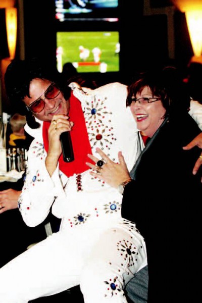 Elvis impersonator Paul Larimore sings a tune to Kat Cunningham, the owner of Moresource Inc., at the United Way’s annual fundraising party.