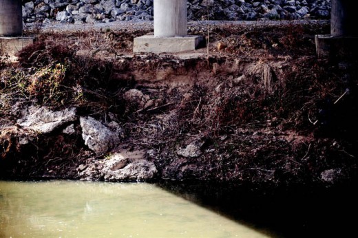 The land on which pillars for a bridge crossing Hinkson Creek sit is eroding because of flash flooding and little in place to stop the erosion.