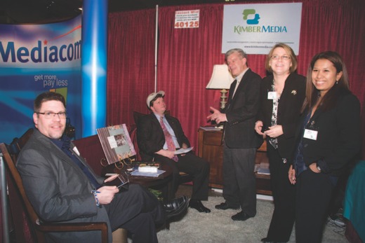 Sean Spence, rear, sits with the four owners of Kimbermedia, from left, J. Michael Roach, Tim Trabue, Kim Trabue and Nelly Roach. The owners celebrated the launch of their social media content management company during the showcase.