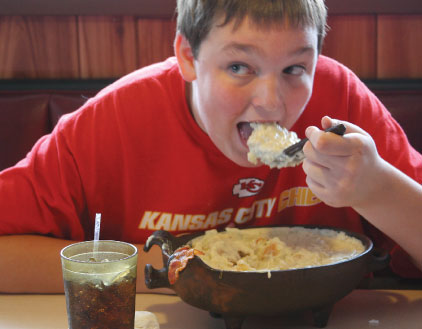 Josh White, 15, digs into The Big 70:  seven biscuits with 70 ounces of gravy and four pieces of bacon