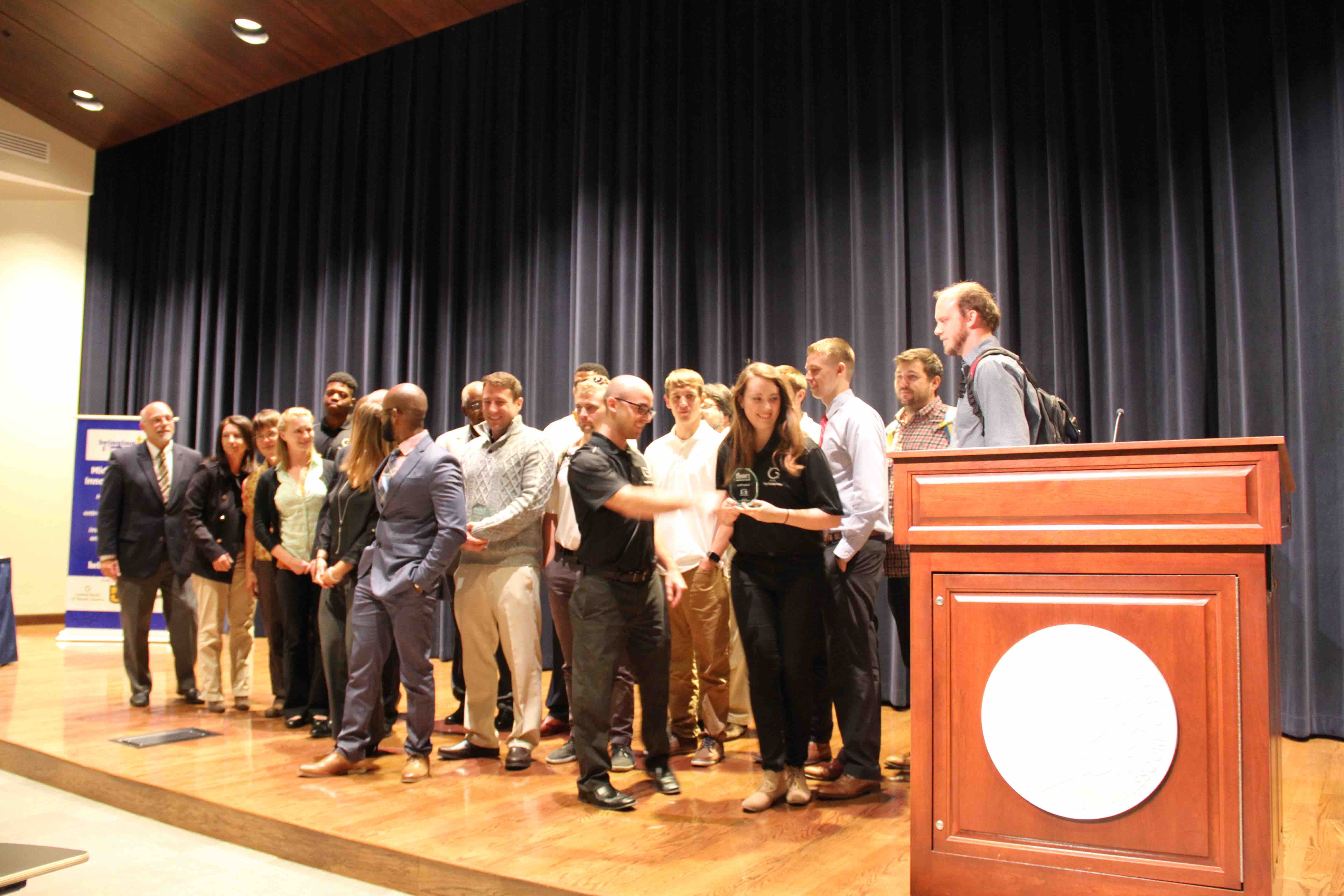 The participants in Monday's pitch competition for Bringing Up Business Innovation Week gather on stage.