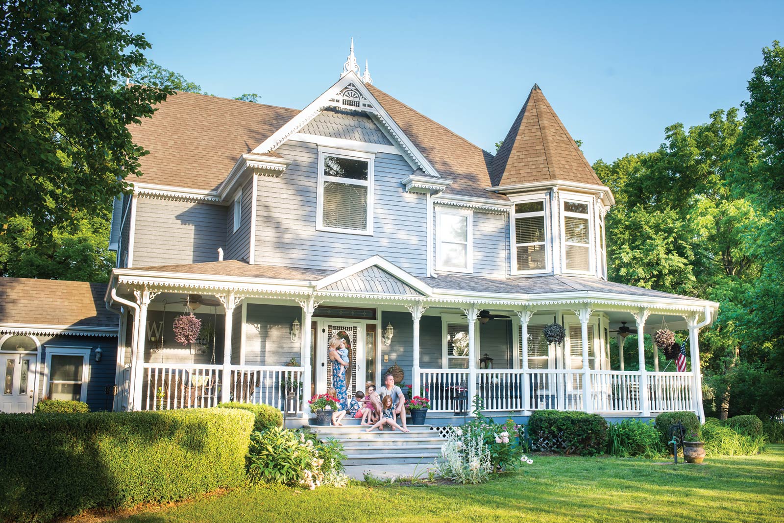 The Wood family from Columbia MO posing on their Victorian home's front porch