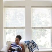 Adonica Coleman reading on her loveseat at home