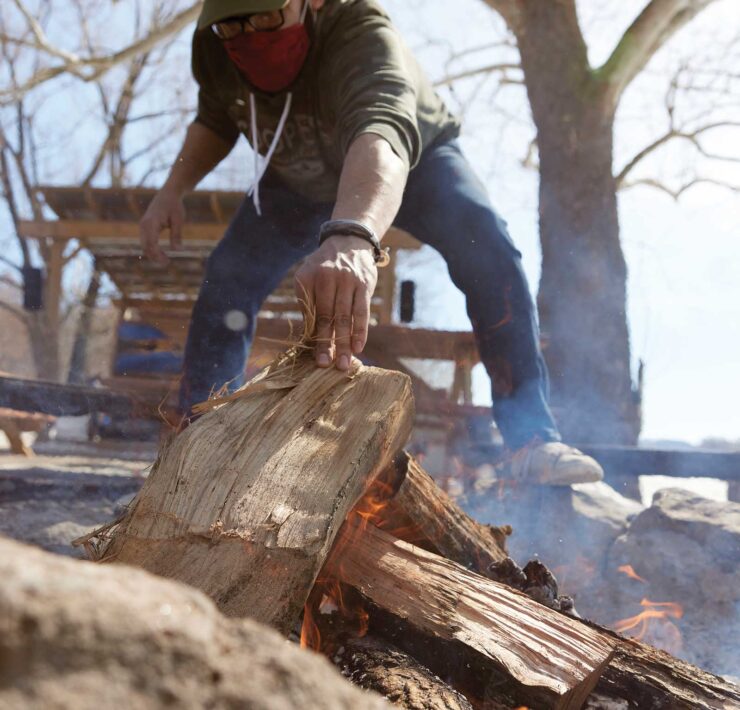 Michael De Leon builds a fire at Cooper's Landing on the Missouri River
