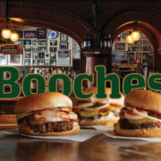 3-Booches-Burgers-Overlaying-the-word-Booches-in-green-text-outlined-in-gold-with-the-Bar-in-the-background
