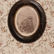 Portrait-of-Sanford-and-Kate-Conley-in-Oval-vintage-frame-hanging-on-floral-wallpaper.