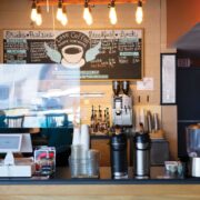 interior of a coffee shop with a large chalk board menu above the front counter