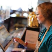 A female barista using a register machine