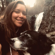 women and her dog take a selfie next to a waterfall