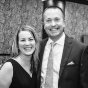 black and white image of a man and women smiling for the camera