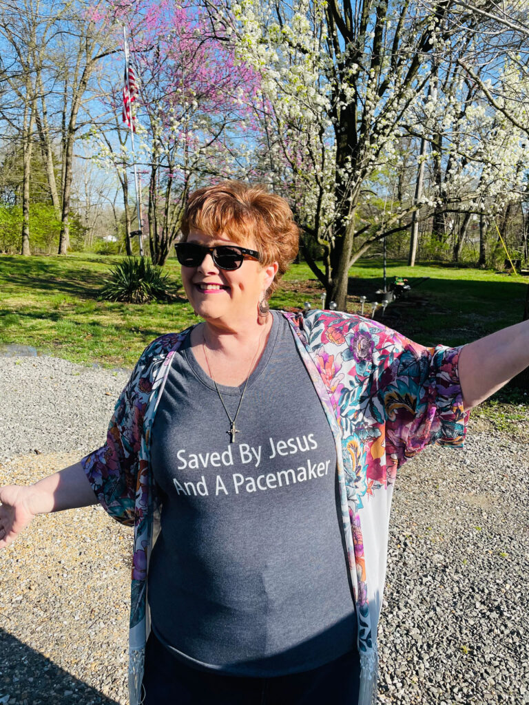 a women smiling in front of a bunch of flowering trees outside