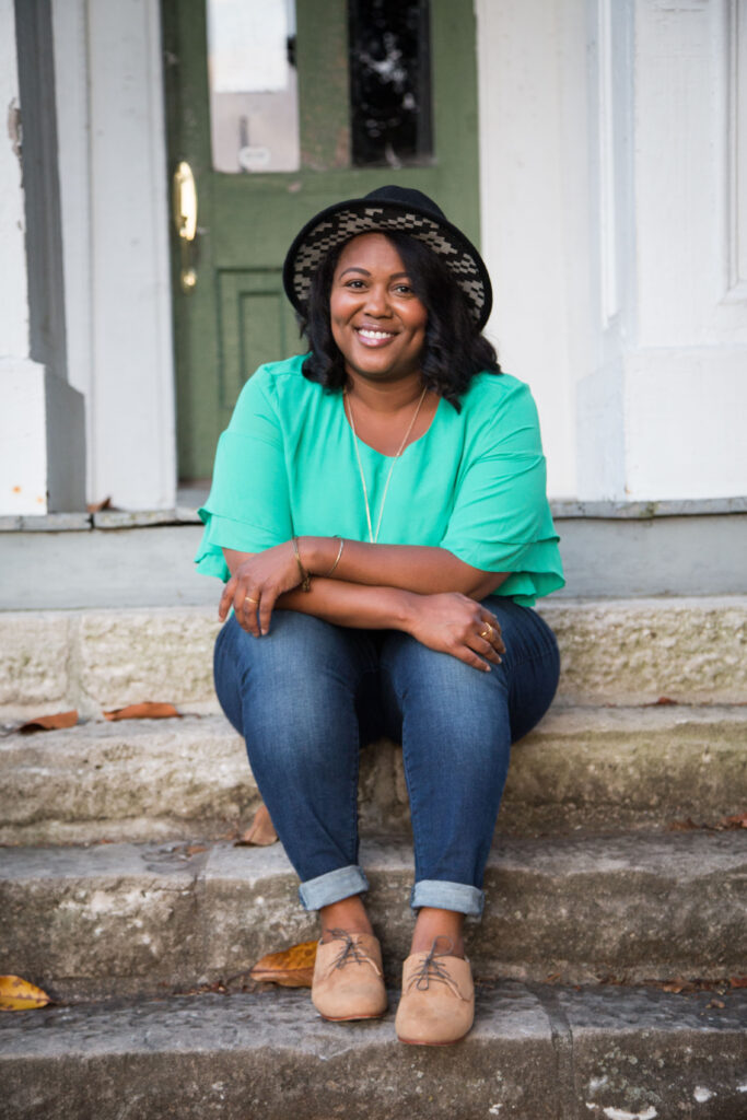 headshot of a women named Robin Robinson sitting on the steps of a front porch