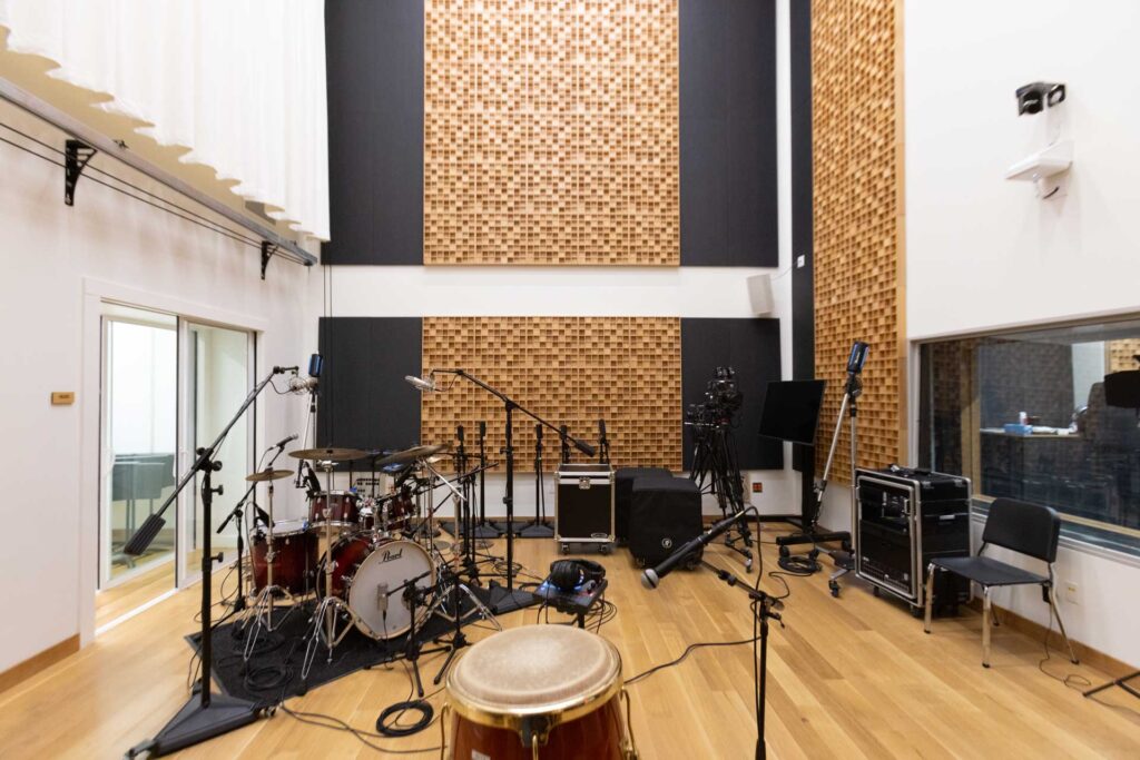 a recording studio with soundproof material on the walls and a array of instruments set up in the room