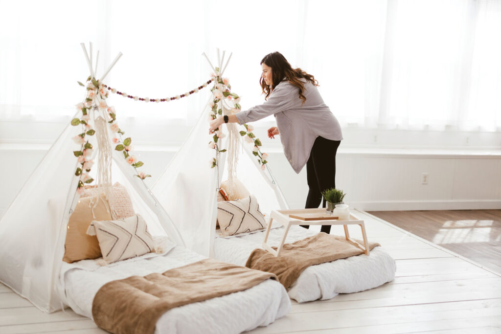 Erica Haynes arranges florals on two white glamping tent inside