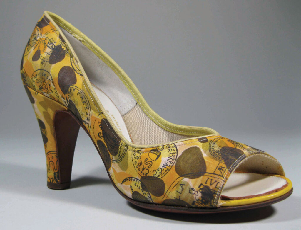 close up of a singular shoe that is a high heel open toed shoe with a yellow and olive green pattern