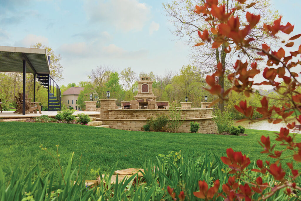 exterior wide angel shot of a outdoor stone and brick fireplace next to a lake