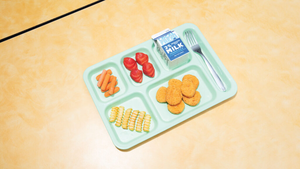 overview of a lunch tray filled with food resting on a wood table