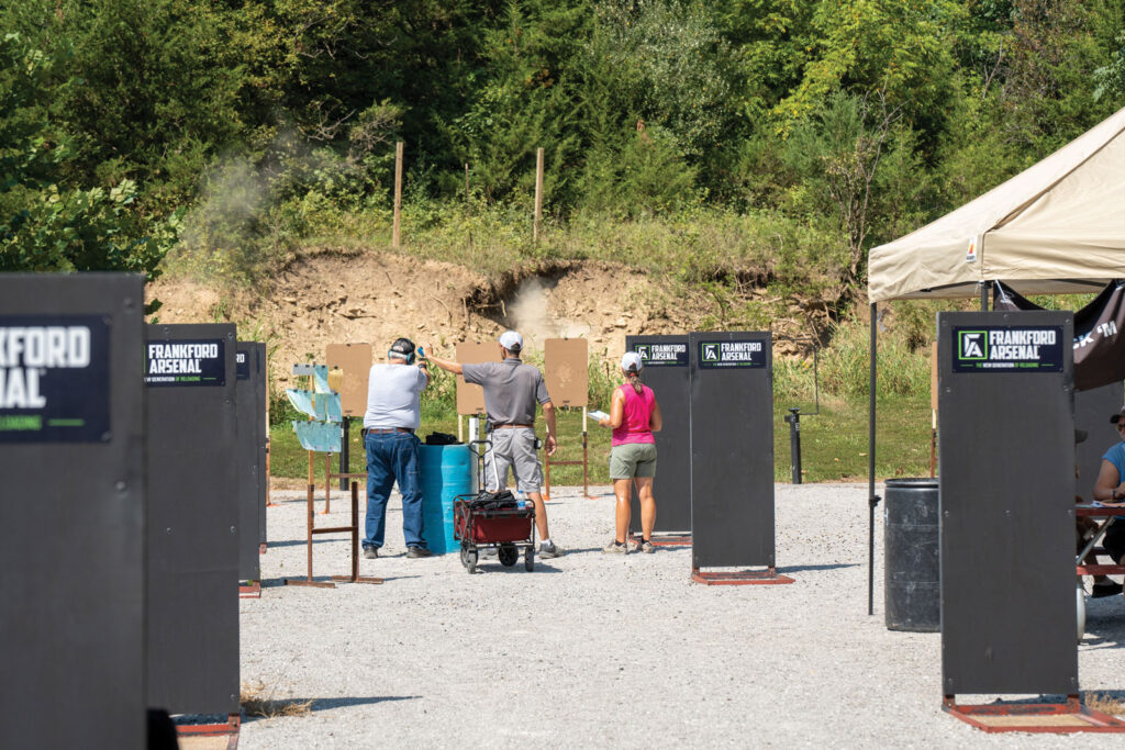 three people aiming at shooting target at an outdoor shooting range