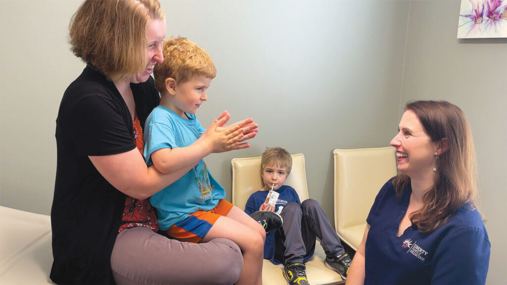 Dr Gruender chatting with a mother and child patient