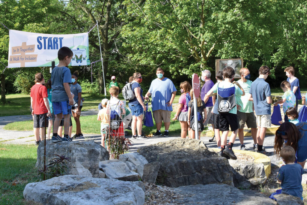 a group of people outside assembled at the starting line of the Kindness Walk