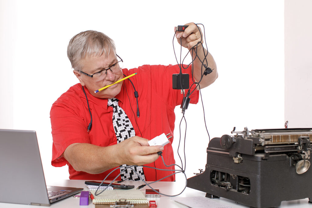 Reporter searches for where to plug a phone charger into a typewriter.