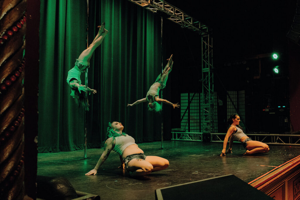 four Muse Pole Fitness members preforming live on stage