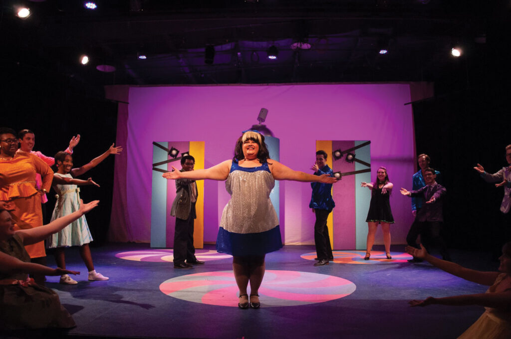 View of actors on stage preforming a musical called Hairspray. Production put on by the Columbia Entertainment Company.