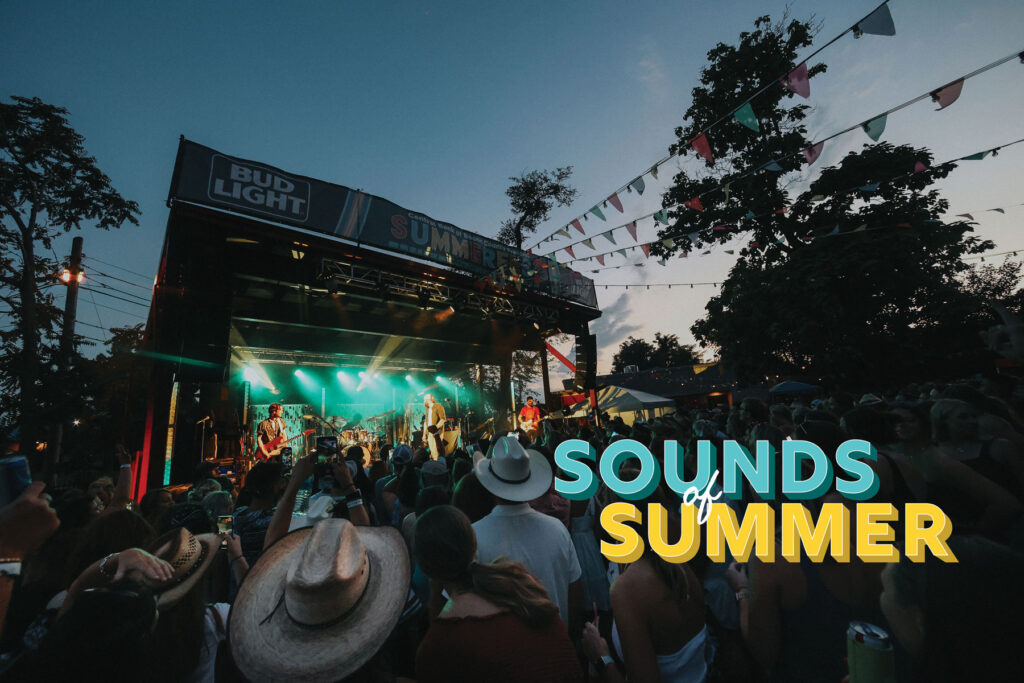 view from busy crowd at a outdoor concert with the text 