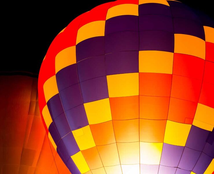 Image of a brightly colored hot air balloon against a dark night sky.