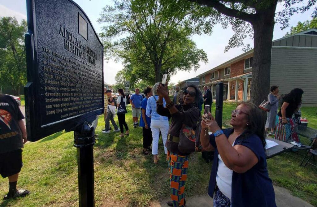 Jacqueline Kelly and Sharon Brooks Miller take photos of the new marker along Columbia's African American Heritage Trail.