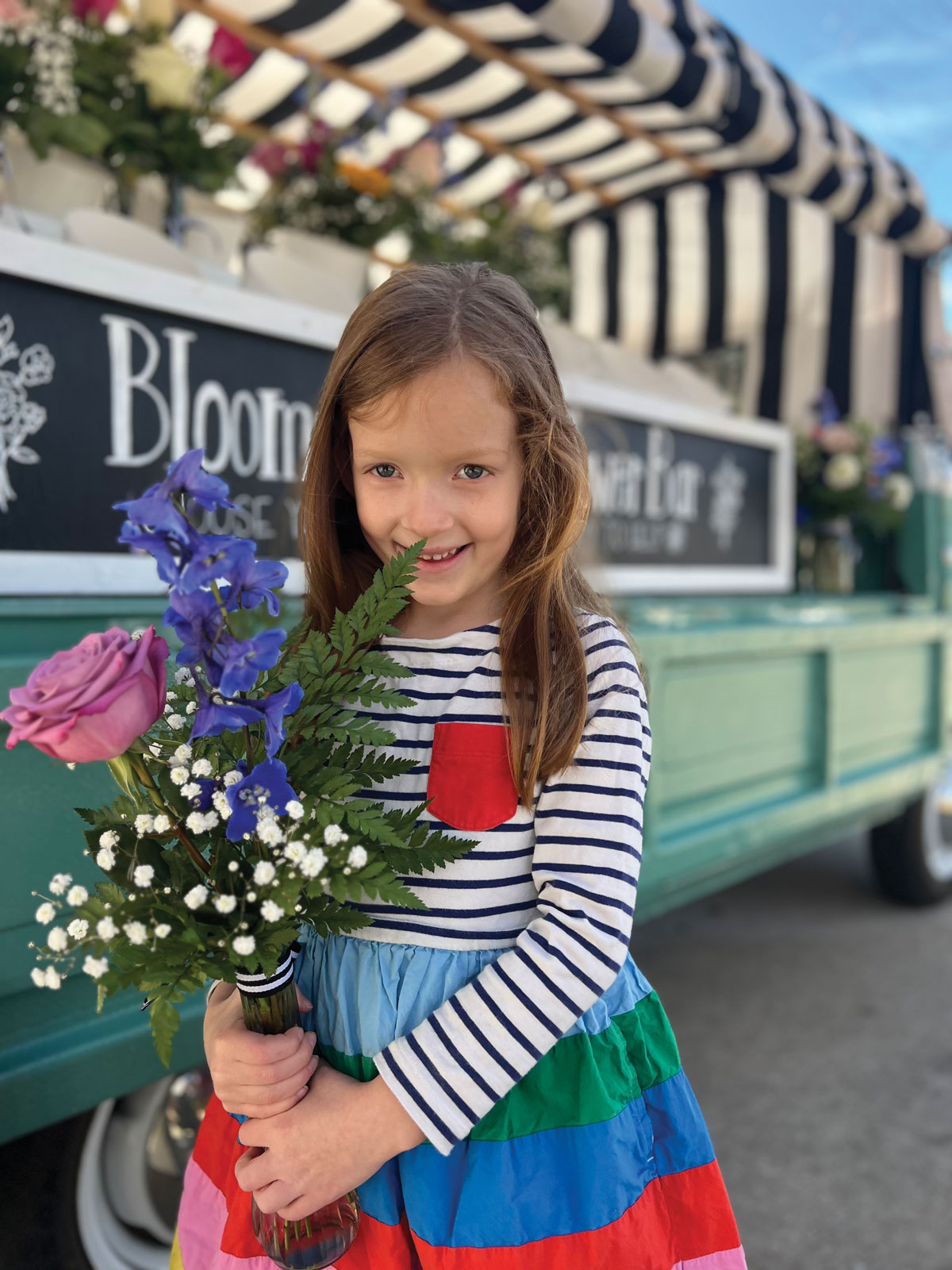 Blooms and Wishes Flowers: a little girl holding a bouquet