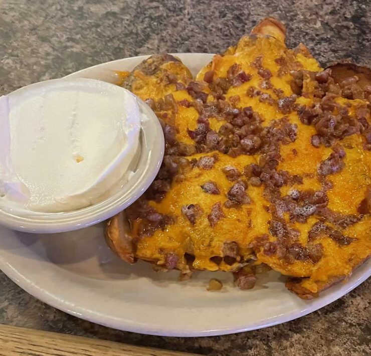 A plate of bacon and cheddar potato skins with dipping source, served up by The Heidelberg in Columbia, MO.