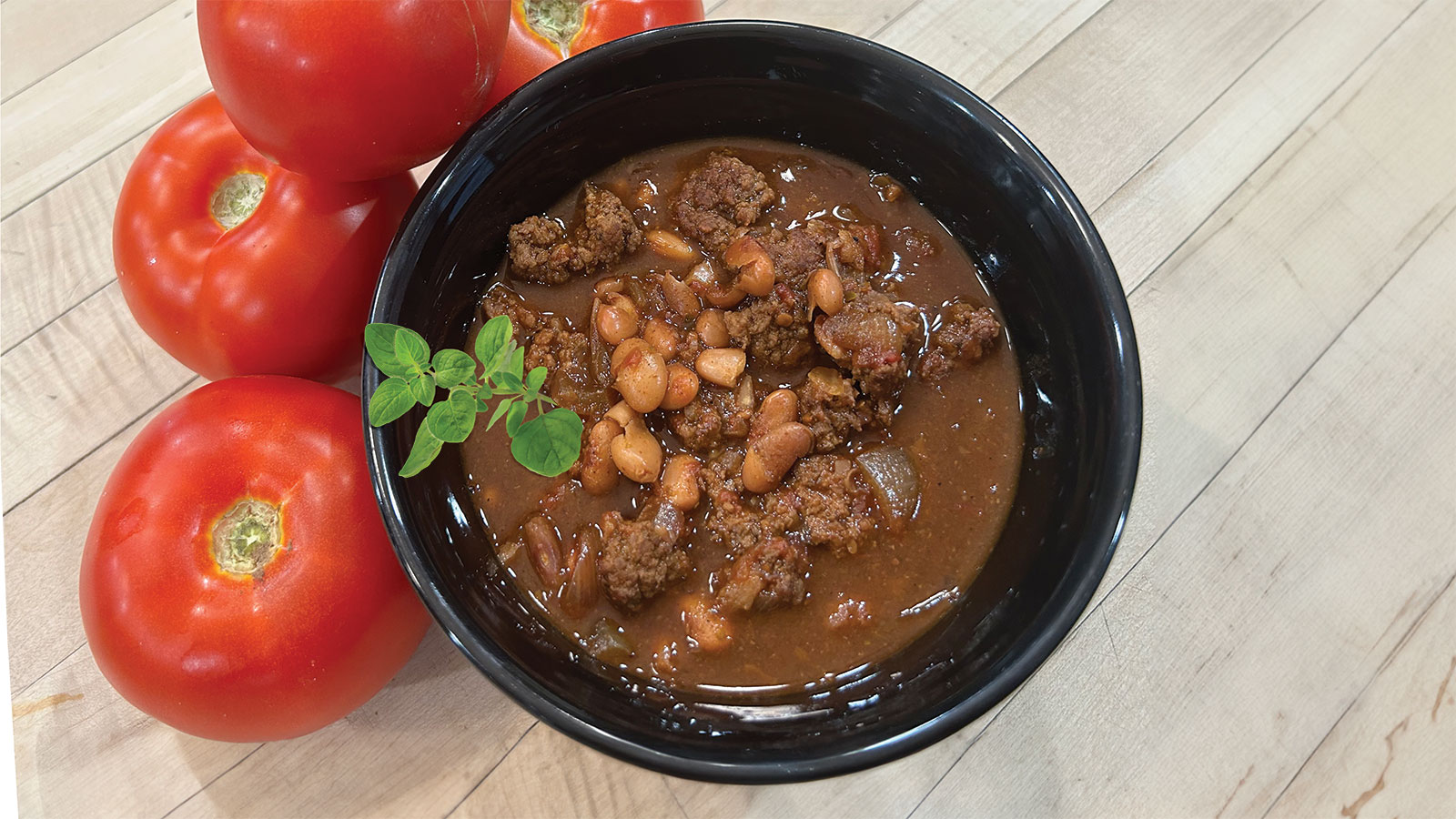 Spicy Texas Chili with Oregano Sprig and Tomatos