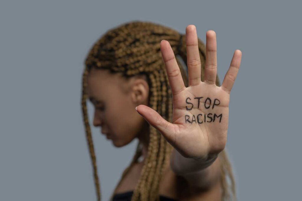 Gettyimages women holding up her hand which has the written words Stop Racism